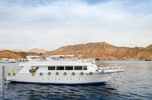 big white boat in the Red Sea on the background of a rocky coast in Egypt © Sofiia
