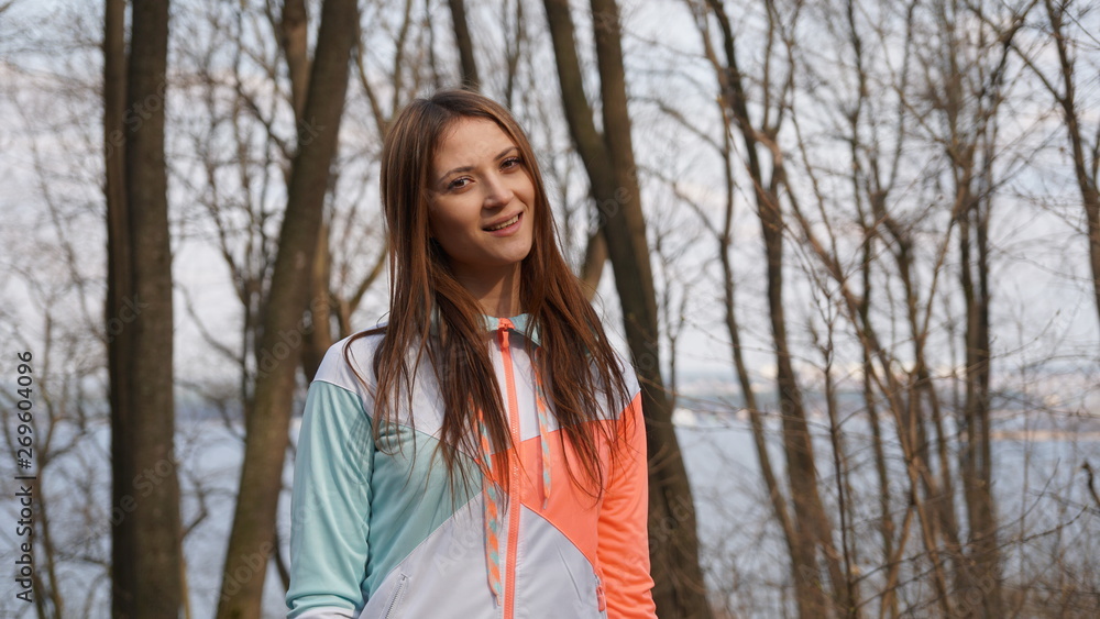 Adorable sporty girl in sportswear smiles in a forest. Adorable sporty girl in sportswear smiles in a forest.