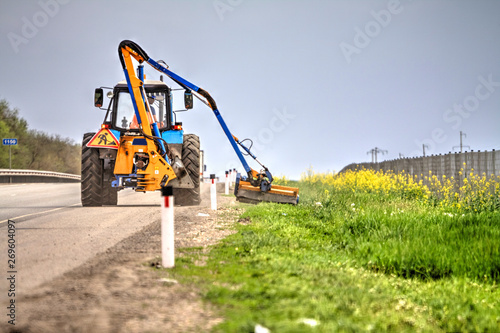 Tractor with a mechanical mower mowing grass