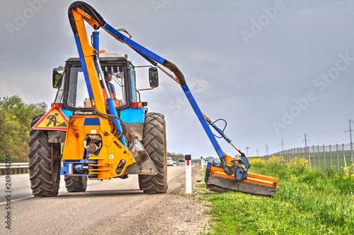 Tractor with a mechanical mower mowing grass