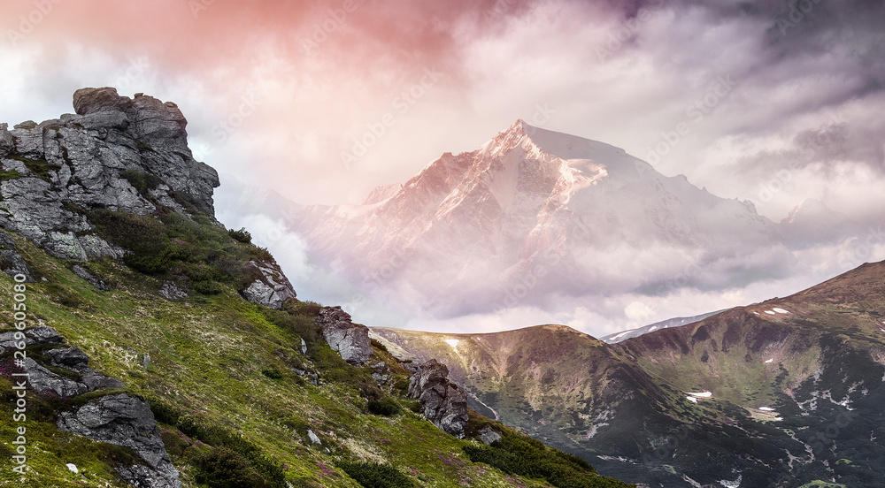 Magical Mountains Landscape. Majestic Sunset. Overkast sky over Rock Peak under sunlit. Awesome Alpine highlands in Summer Day. Amazing sunrise in the mountains. Picture of wild area. Creative image