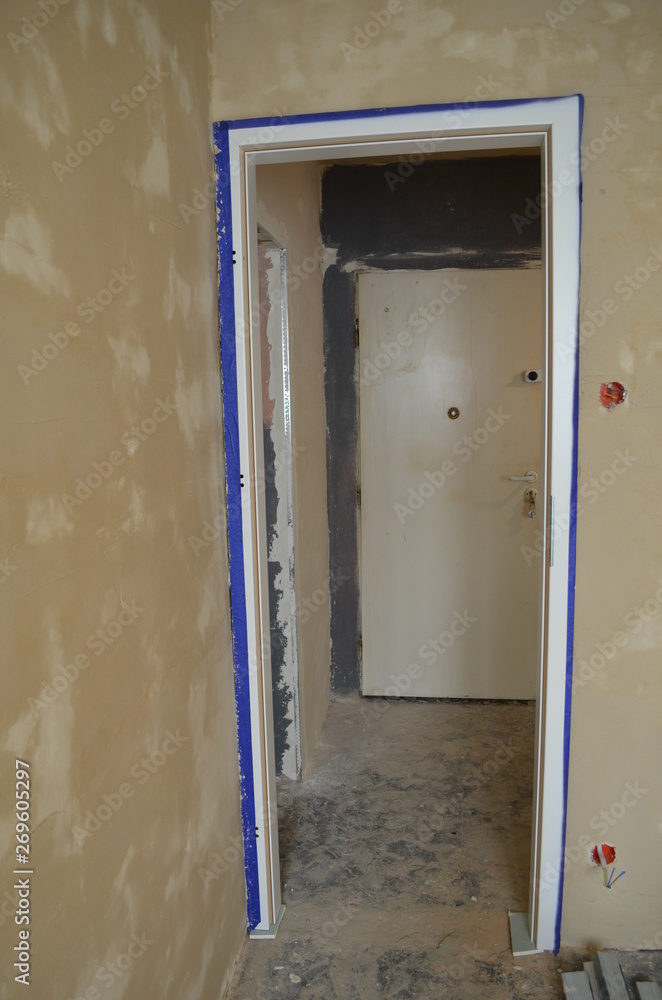 Fototapeta premium Remont mieszkania - nowa oscieżnica drzwiowa, mokre tynki strukturalne na ścianach