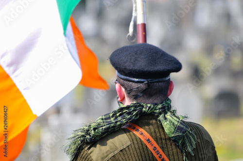 A man in paramilitary uniform, with an Irish tricolour as he commemorates the Easter Rising of 1916
