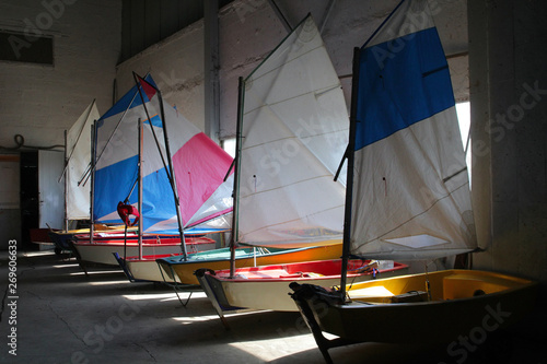 Multicolored sailboats in the boat shed.