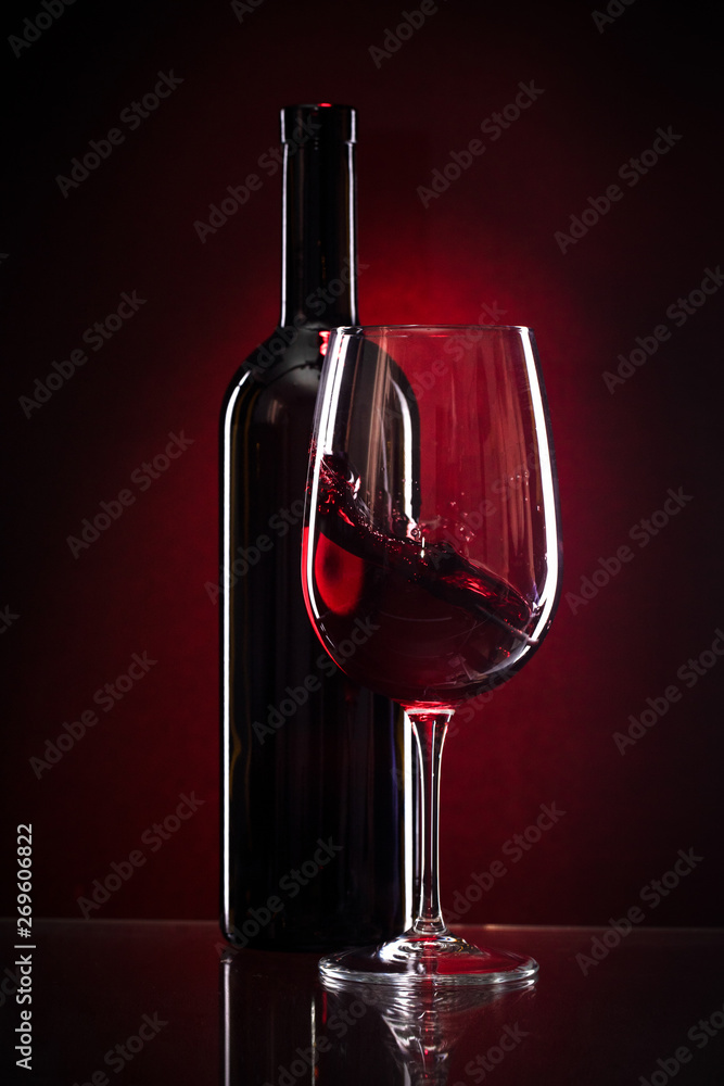 wine glass and bottle of red wine on a dark red background Stock Photo |  Adobe Stock