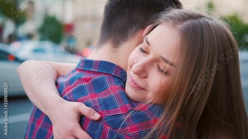 Care and love expression. Sincere and intimate embrace. Closeup of young couple hugging in the street.