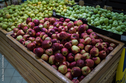 Ripe apple in wooden box Fresh striped apples in wooden box with straw