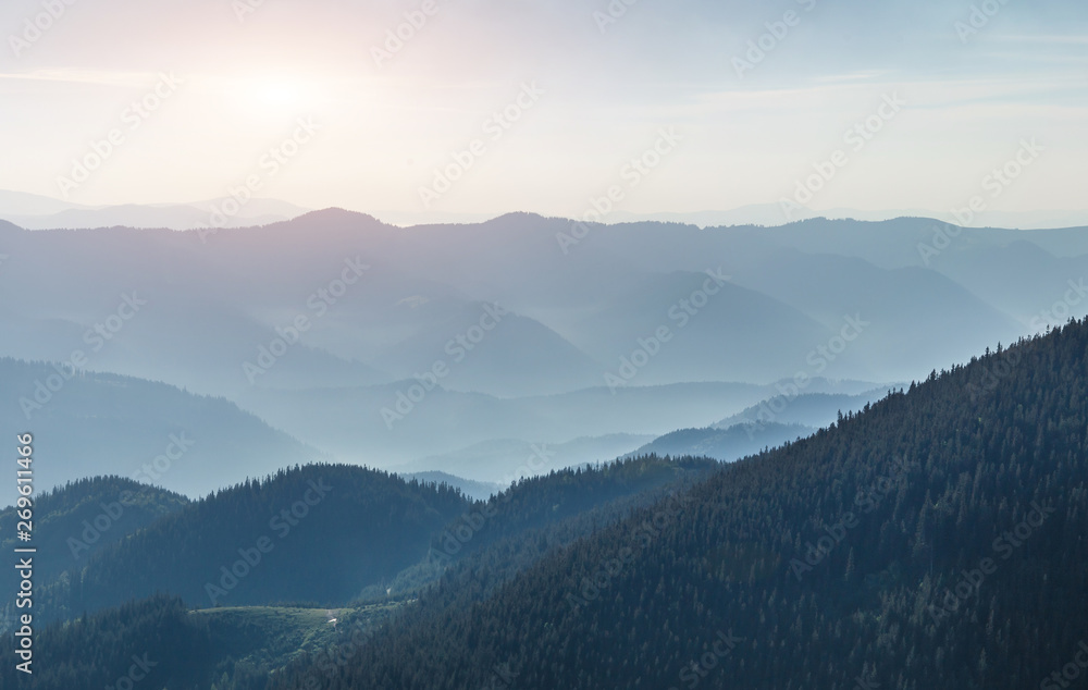 Mysterious Foggy sunrise at Mountains. Awesome Sunny Sammer Landscape under morning Sunlight. Wonderful Nature Background