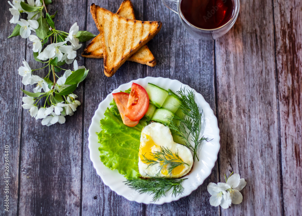 Fried eggs with lettuce, cucumber and tomato slices on wooden background Fried eggs with lettuce, cucumber and tomato slices on wooden background