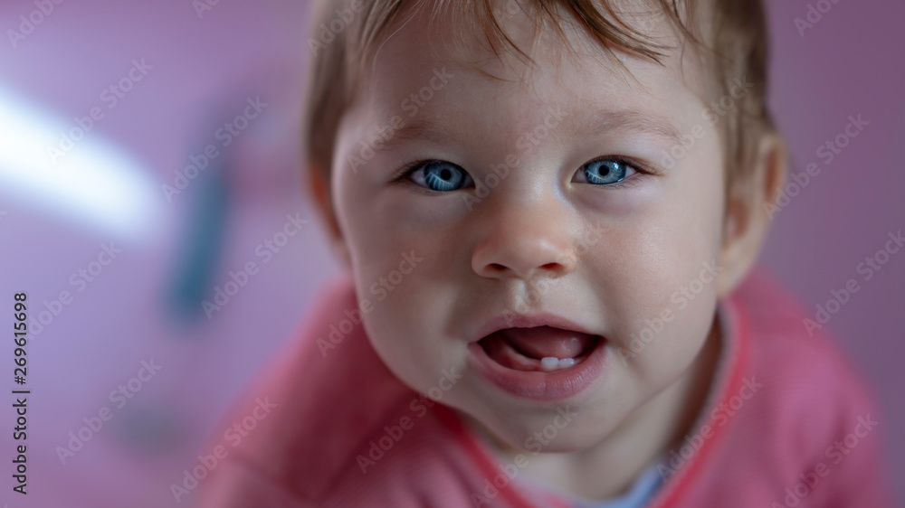 Cute baby with blue eyes on ping background.
