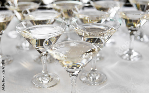 Alcohol cocktails, martini, vodka and others on decorated catering bouquet table on open air event or wedding.
