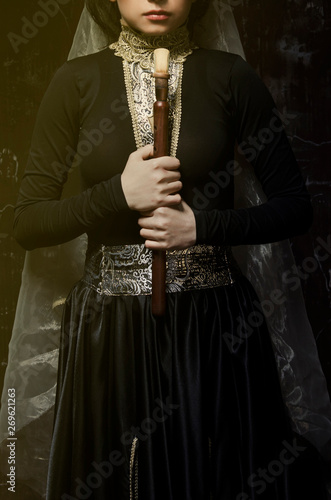 woman in traditional armenian dress holding duduk in hands