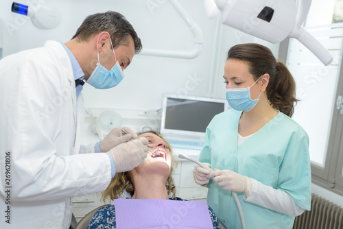 dentists making procedures with his patient in dental office