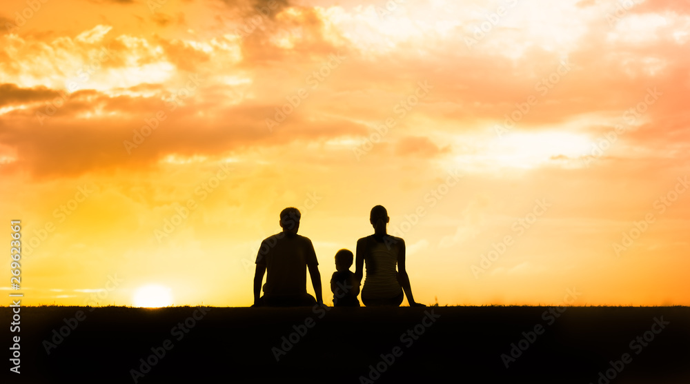 Family sitting together watching beautiful sunset. 