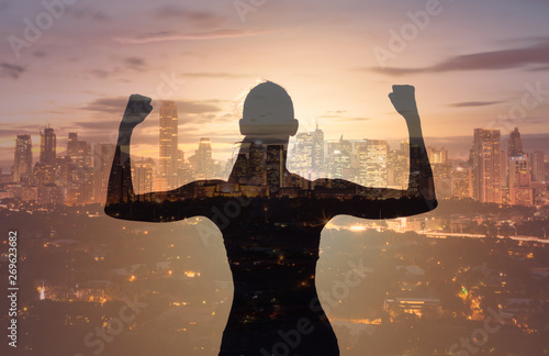 Obraz na plátne silhouette of strong victorious woman  on city background