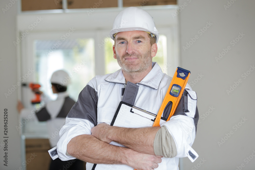 professional worker posing with spirit level at construction site professional worker posing with spirit level at construction site