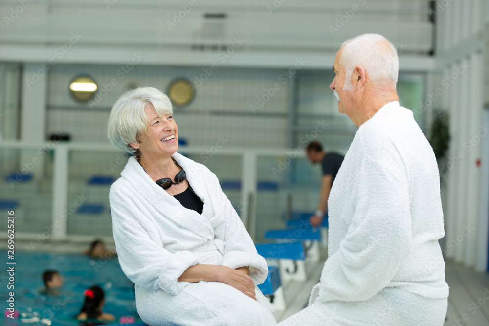 Obraz premium elderly people talking casual next to swimming pool