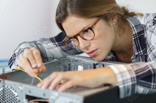 concentrated young woman fix pc component in service center