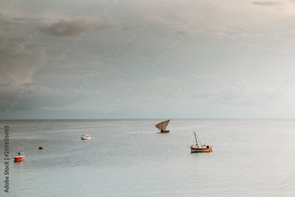 Naklejka premium old sailing boat in the ocean at sunset