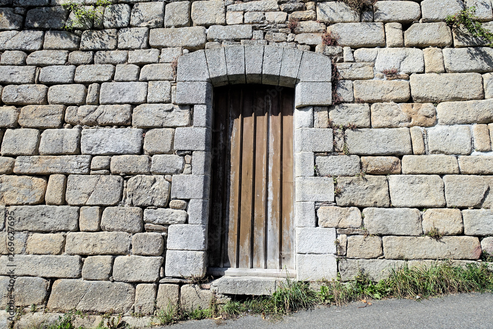 Wooden door in the stone wall