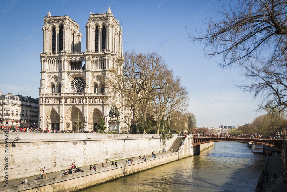 Parisian landscape of Paris quays under a beautiful blue sky at the end of spring at the foot of the famous cathedral Notre Dame - Paris, France