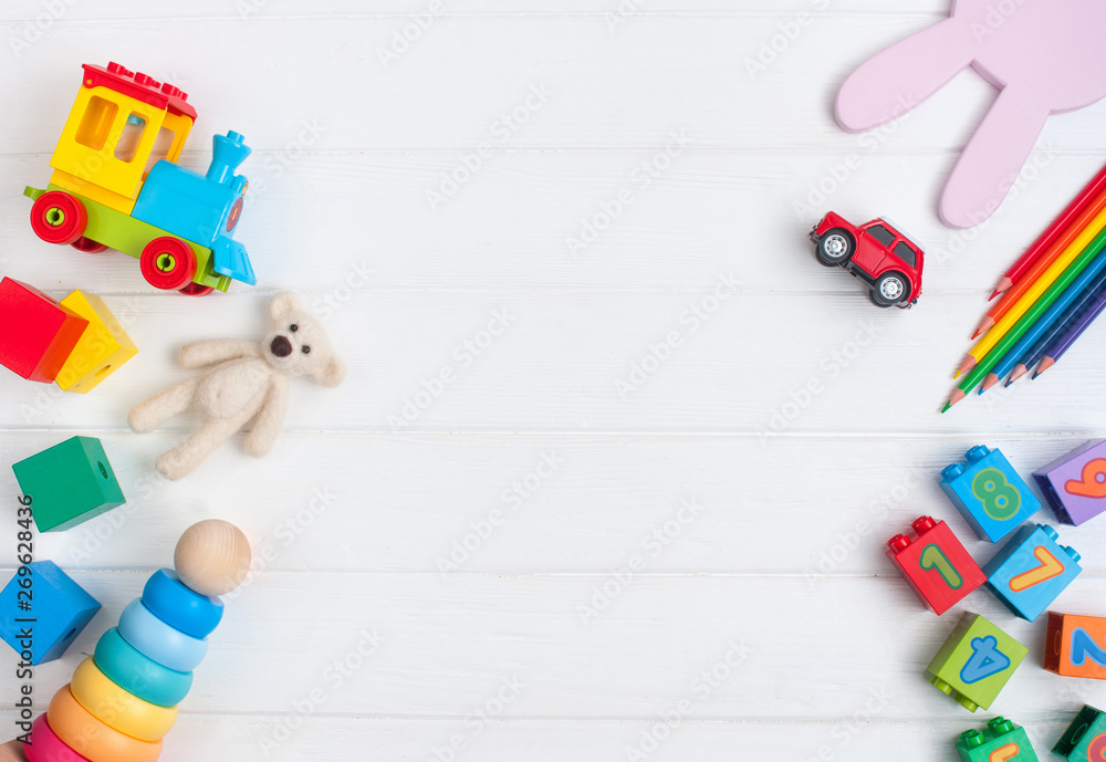 Frame of kids toys on white wooden background with copy space - obrazy, fototapety, plakaty 