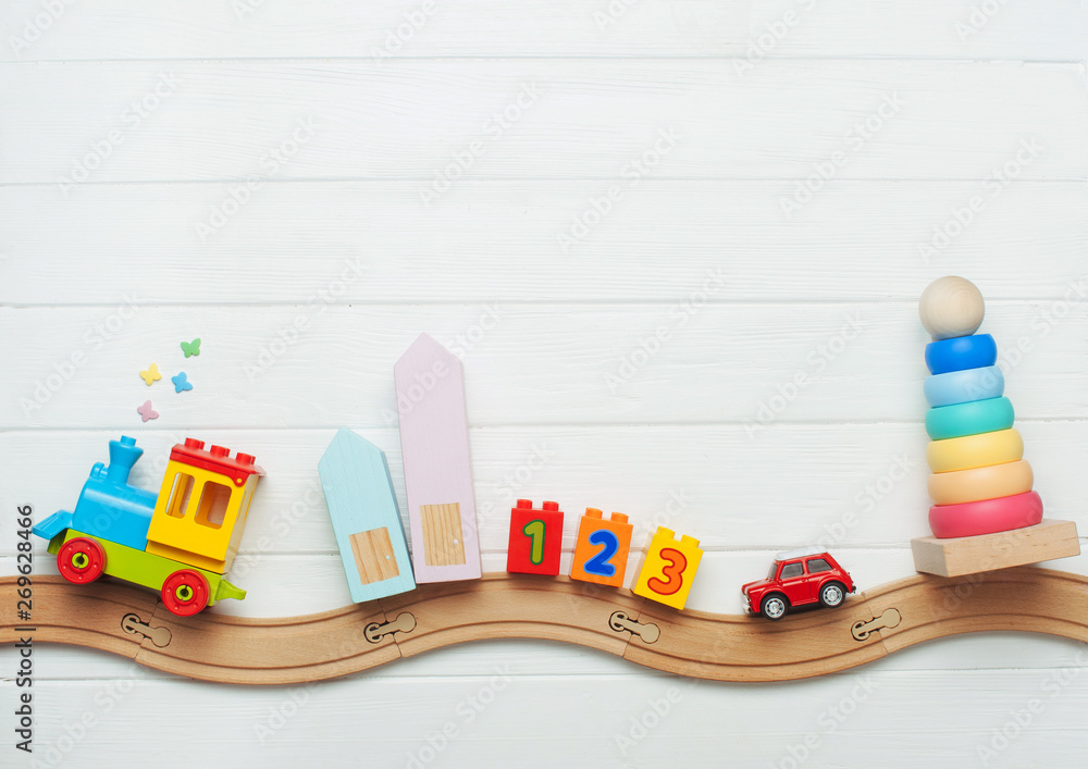 Kids toys on toy wooden railway on white wooden background - obrazy, fototapety, plakaty 