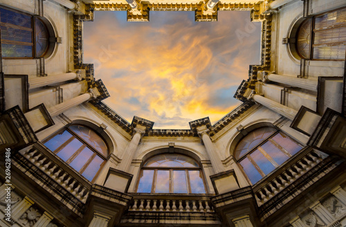 Heraklion, Crete Island / Greece. Venetian Loggia, looking up to the atrium from the building's courtyard. Loggia houses the town hall of Heraklion. Colorful sunset with cloudy sky