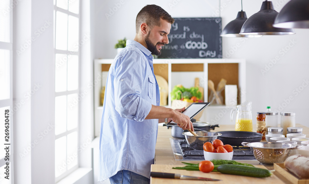 Smiling and confident chef standing in large kitchen Smiling and confident chef standing in large kitchen
