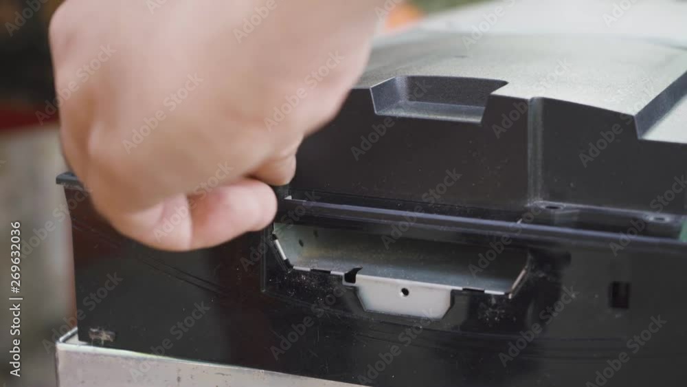 The specialist unscrews the screw from the cover of the game console The specialist unscrews the screw from the cover of the game console