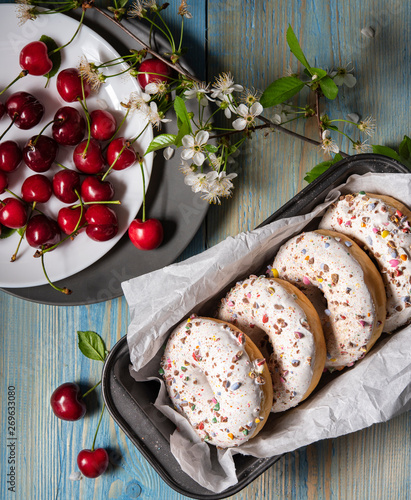 some donuts bakerry with cherry berry on the blue wood table rustic blossom photo