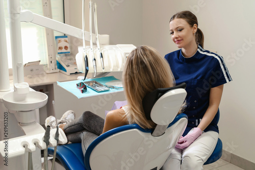 The woman came to see the dentist. Young woman having dental check-up in dentist s office  smiling  looking at camera. Happy patient and dentist concept.