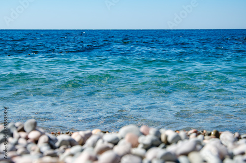 Seascape, view of pebble beach close up and clear turquoise sea