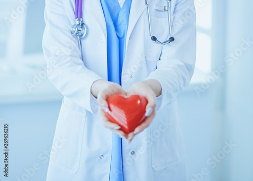 Doctor with stethoscope holding heart, isolated on white background
