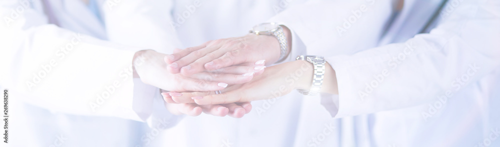 Naklejka premium Doctors and nurses in a medical team stacking hands