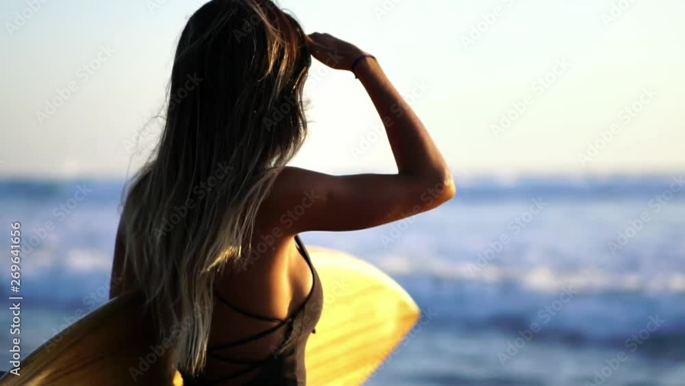 Sexy athletic girl in a swimwear bikini on the beach, background of the sea. Healthy Active Lifestyle. Surfing, Fashion. Summer Vacation. Slow motion. Sexy athletic girl in a swimwear bikini on the beach, background of the sea. Healthy Active Lifestyle. Surfing, Fashion. Summer Vacation. Slow motion.