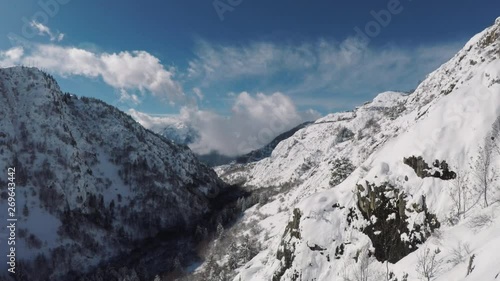 Wallpaper Mural Steep mountain slopes and sheer rock faces drop into a narrow valley. Blanket of fresh soft white snow on rugged terrain. Aerial view of a skiers paradise and winter landscape. Torontodigital.ca