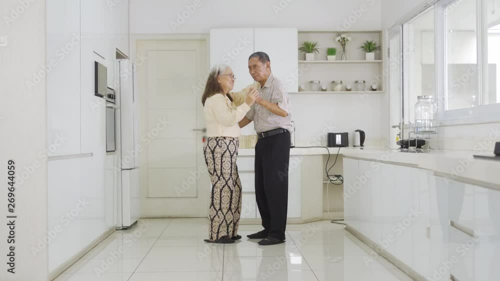 Happy senior couple dancing together in the kitchen at home. Shot in 4k resolution Happy senior couple dancing together in the kitchen at home. Shot in 4k resolution