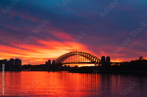 Silhouette of Sydney Harbour Bridge with orange burning sky at dawn. © AlexandraDaryl