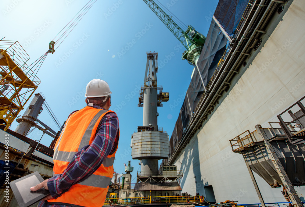 stevedore or foreman, engineering, loading master talks to crane driver by walkie talkie for safety lifting the goods shipment, lifting by gantry crane, working at risk on the high level insurance stevedore or foreman, engineering, loading master talks to crane driver by walkie talkie for safety lifting the goods shipment, lifting by gantry crane, working at risk on the high level insurance