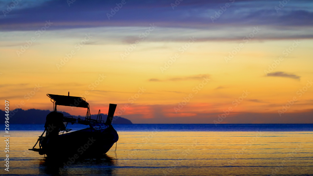 a silhouette boat with colorful sunset and the sea in Krabi, Thailand