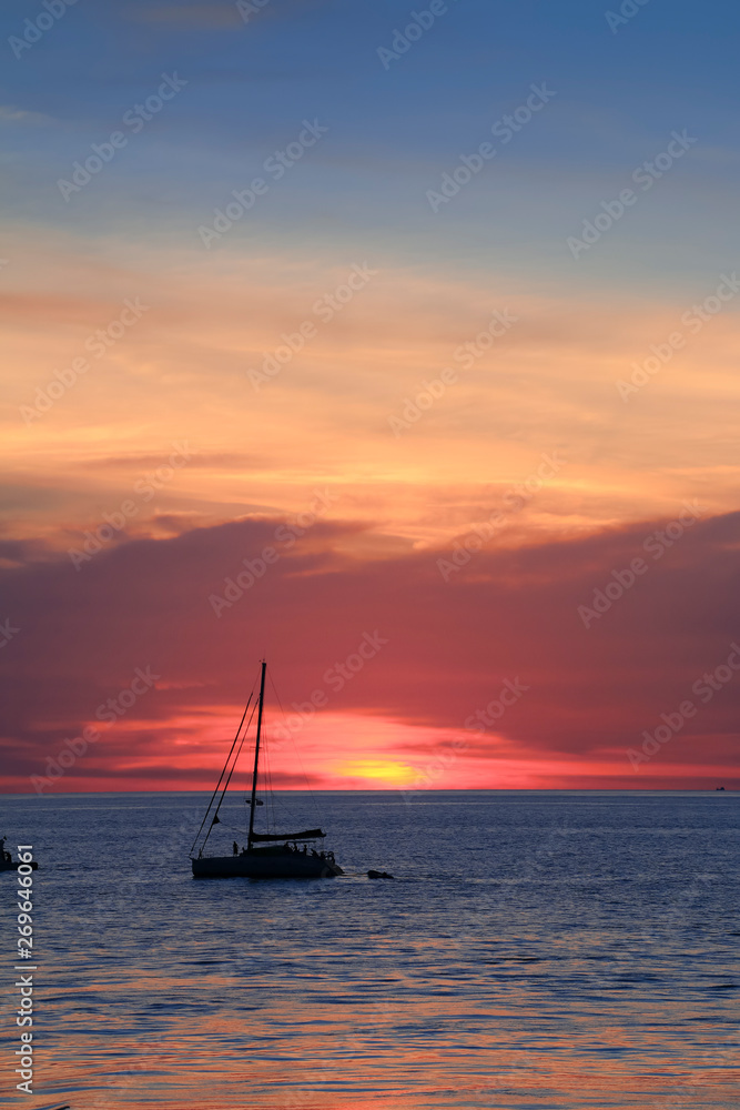 a silhouette boat with colorful sunset and the sea in Krabi, Thailand
