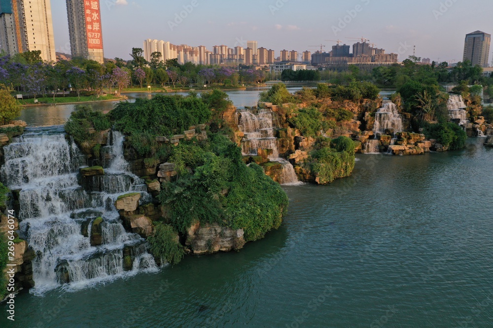 Kunming, China – May 17 ,2019: Aerial 360 degree view of the Kunming Waterfall Park at sunset, one of the largest manamde waterfalls in the world