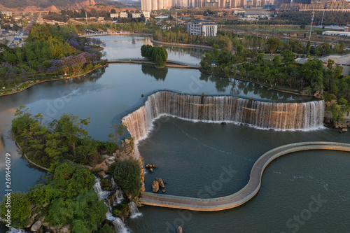 Aerial 360 degree view of the Kunming Waterfall Park at sunset, one of the largest manamde waterfalls in the world photo