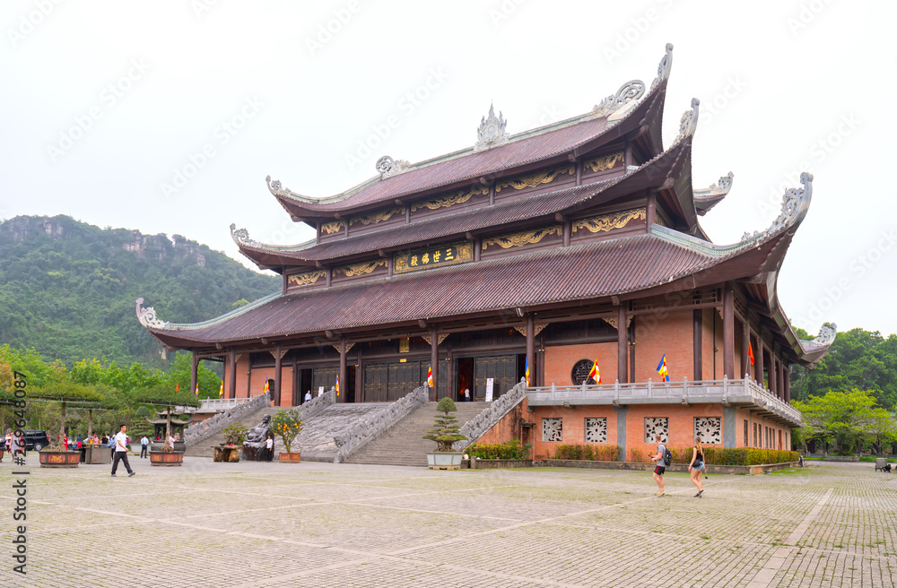 Fototapeta premium Ninh Binh, Vietnam - April 5th, 2019: Tam The Buddha's main architecture in Bai Dinh temple complex attracts tourists to visit, one of the largest in the south east asia in Ninh Binh, Vietnam