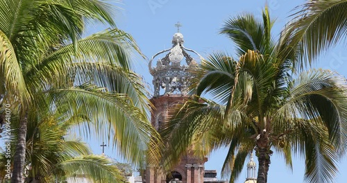 Puerto Vallarta Church of Our Lady of Guadalupe palm trees. Mexican beach resort city on the Pacific Ocean. International tourist destination. Climate, scenery, tropical beaches, cultural history. photo
