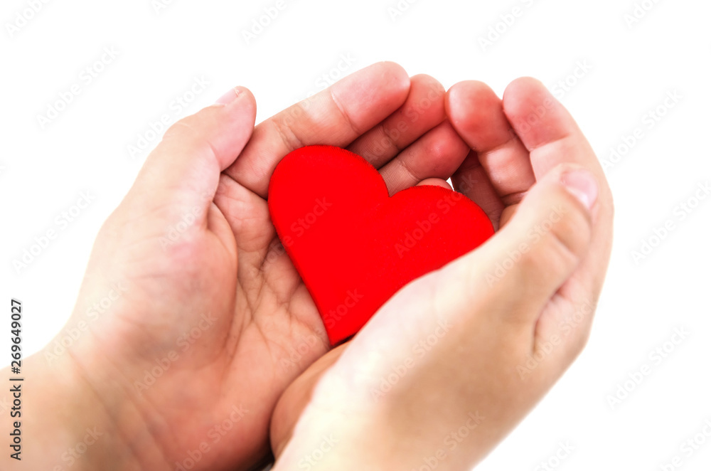 Red heart in the children's palms, isolated on white background. Close-up. Red heart in the children's palms, isolated on white background. Close-up.