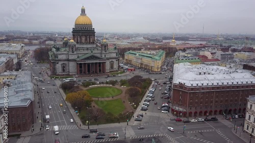 Aerial view; drone flight near the gilded dome of St. Isaac's Cathedral, Exterior Isaakievskiy Sobor, Saint Petersburg, Russia; typical cloudy gray weather near Baltic sea photo