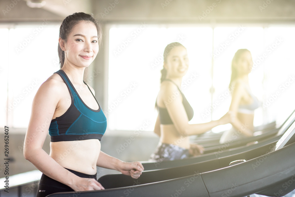 Group of running women on treadmill in fitness gym Group of running women on treadmill in fitness gym