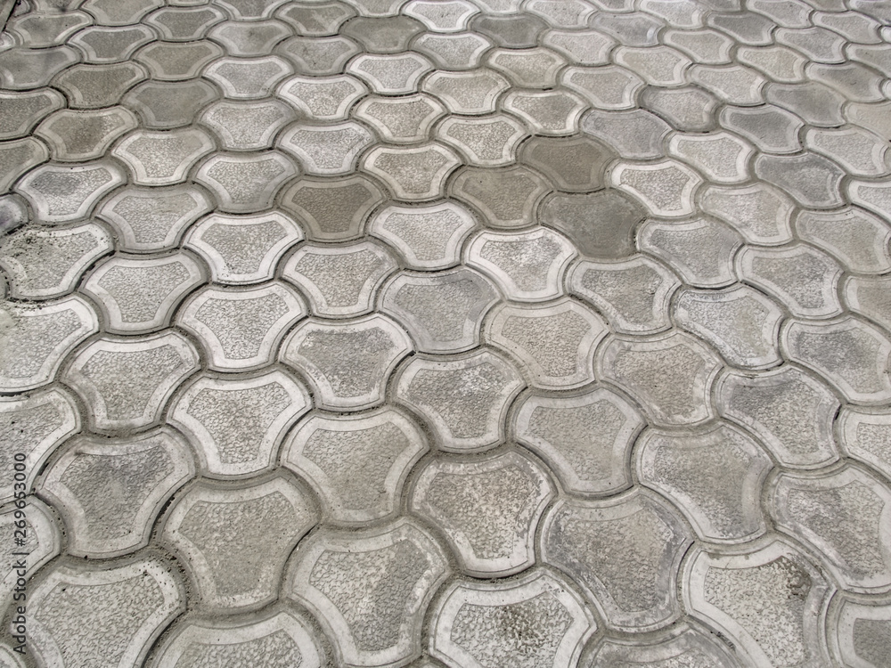 Texture of newly-laid gray curly paving tiles 'Bikini', top view. Abstract pattern of the surface of the paving slabs in the patio, courtyard, garden or square, nobody Texture of newly-laid gray curly paving tiles 'Bikini', top view. Abstract pattern of the surface of the paving slabs in the patio, courtyard, garden or square, nobody